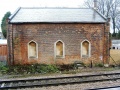 A side on view of the goods shed showing the bricked up gothic arched windows.