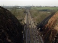 Looking west in the direction of Bristol Parkway. In the distance is the bridge at Curtis Lane. The bridge at Mill Road can be seen where the sign with a T on it is in the photo. Beyond that is Winterbourne Viaduct, with the motorway just visible running right to left.