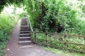 The view in the direction of Monmouth. The railway path is blocked and a flight of stairs provides access to the bridge across the Wye to Brockweir.