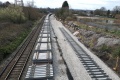 Looking south from the bridge at piles of sleepers placed on the mainline.