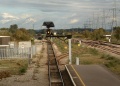 A zoomed and distorted image taken from the footbridge at the station. On the left the line dives down and passes under a bridge which is alongside Caldicot Station before entering the Severn Tunnel.