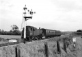 The view towards Pilning Junction. On the right hand side of the photo is Station Road (with a sign warning motorists of a low bridge), while in the distance stock sits on the sidings at the junction. © Gerald Peacock