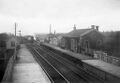 The view west from the station showing the original station building, goods shed and signalbox on the Up platform as well as the Down platform waiting room. Also on view is one of the sidings that used to exist at the west end of the station. The train is the 10.30 from Penzance. © John Brain