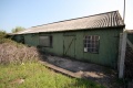 An old shed stands alongside a filled in bay platform at the north end of platform 1.