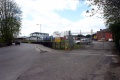 Further up the approach road with a Network Rail depot on the right and the station entrance on the left. © Andrew Ross
