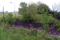 The view north across Pensford Hill showing a surviving bridge abutment and the railway embankment beyond.