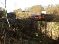 A single car Class 153 scurries towards Keynsham. The bridge in the background is Wick Road.